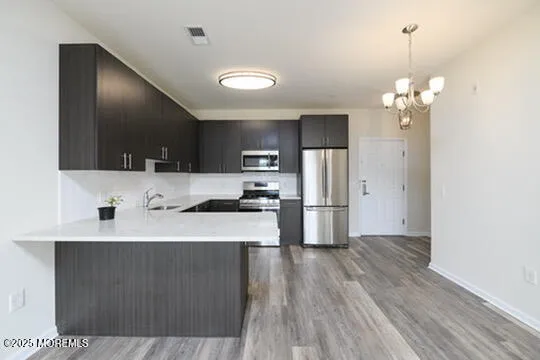 a kitchen with kitchen island a sink stainless steel appliances and cabinets
