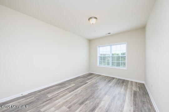 2 Henessey Boulevard, Unit 304 Atlantic Highlands, NJ 07716 - Photo 10 of 19 an empty room with wooden floor and windows