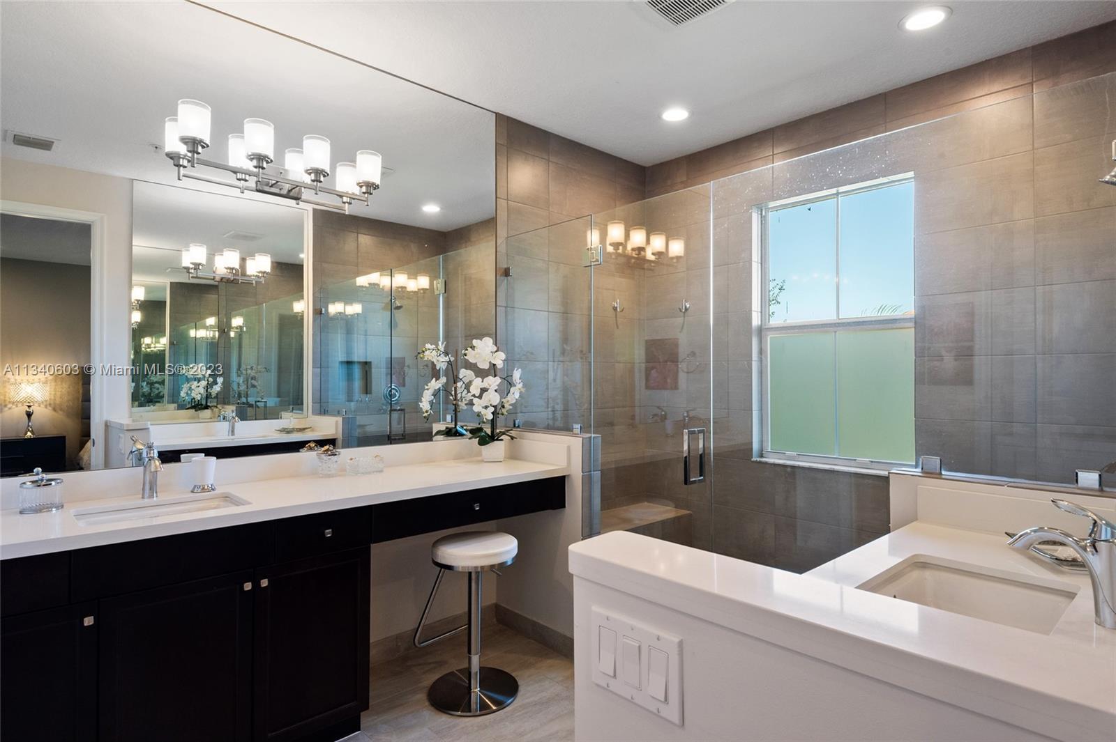 22936 Clear Echo Drive, Unit 34 Boca Raton, FL 33433 - Photo 24 of 41 a bathroom with a sink a large mirror and a shower