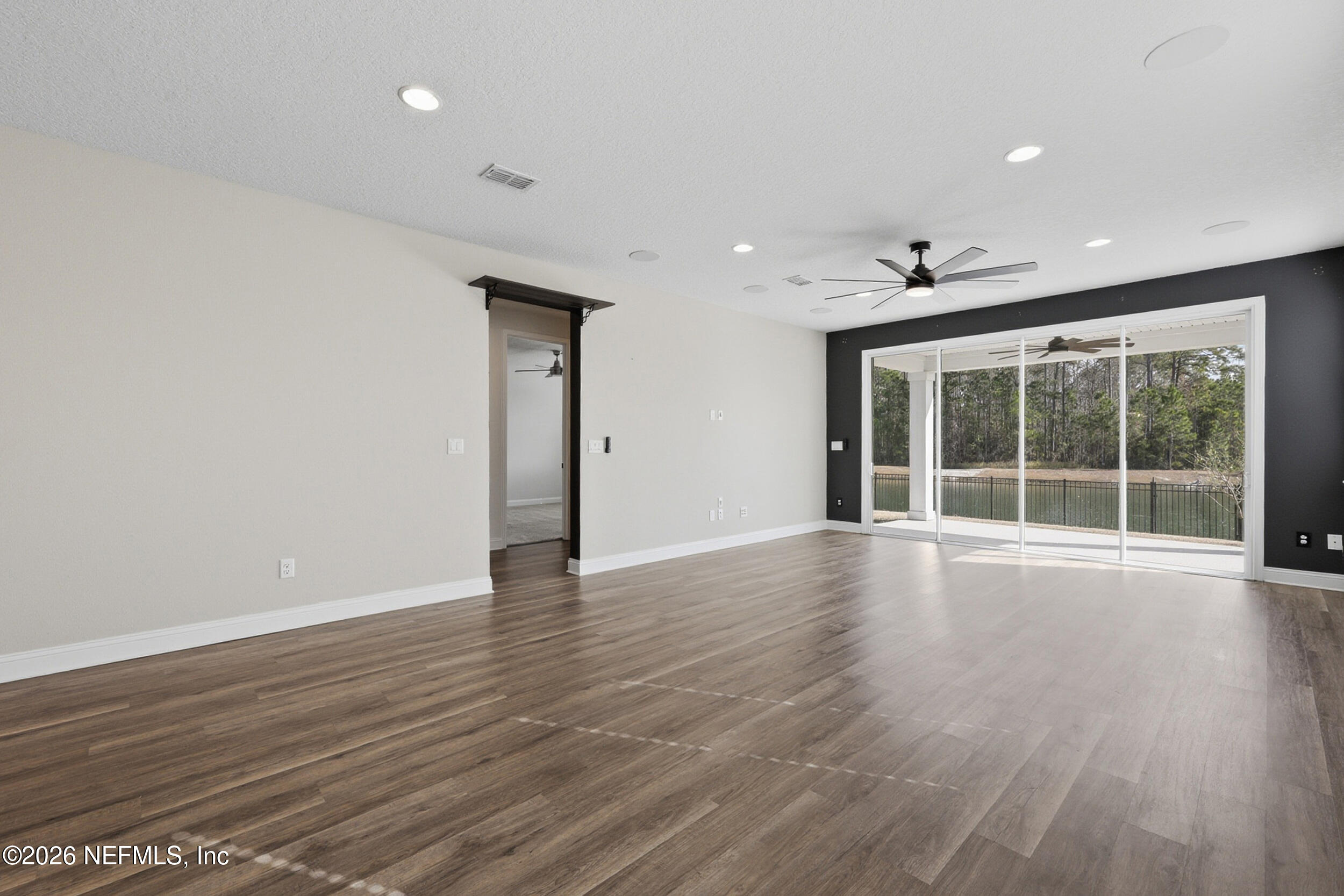 214 Pepperpike Way St. Augustine, FL 32092 - Photo 3 of 63 a view of an empty room with wooden floor and a window