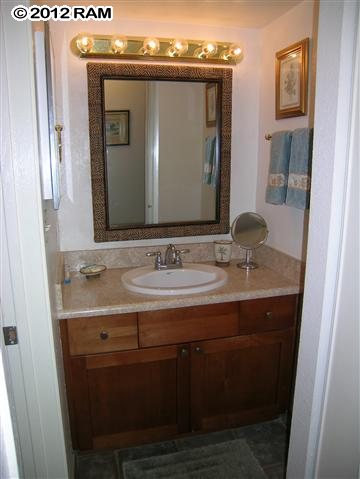 2531 South Kihei Road, Unit C211 Kihei, HI 96753 - Photo 11 of 12 a bathroom with a granite countertop sink a mirror and a vanity