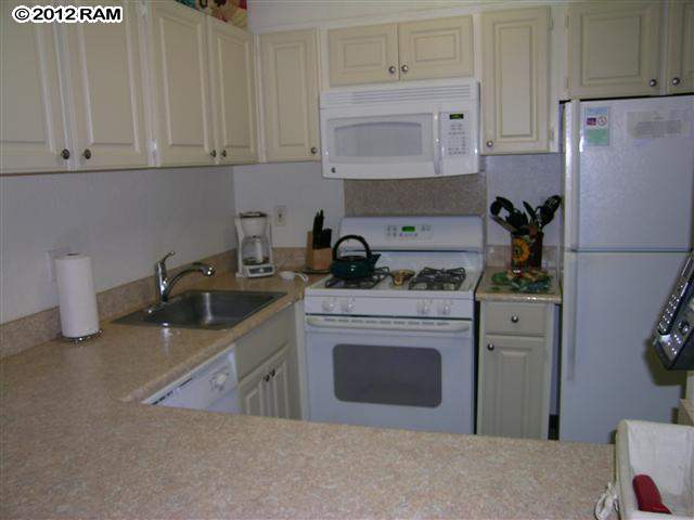 2531 South Kihei Road, Unit C211 Kihei, HI 96753 - Photo 5 of 12 a kitchen with stainless steel appliances granite countertop a refrigerator sink and cabinets