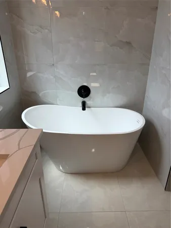 a white tub sitting next to a white sink