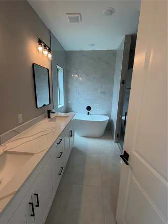 a bathroom with a double vanity sink a mirror and a shower
