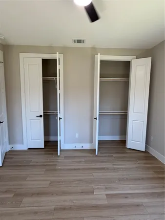 an empty room with wooden floor and closet