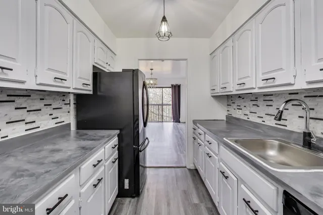 a kitchen with granite countertop a sink stainless steel appliances and cabinets