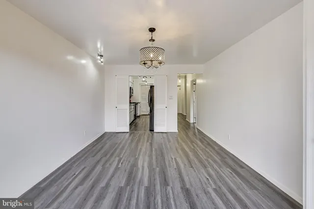 a view of a hallway with wooden floor and a ceiling fan