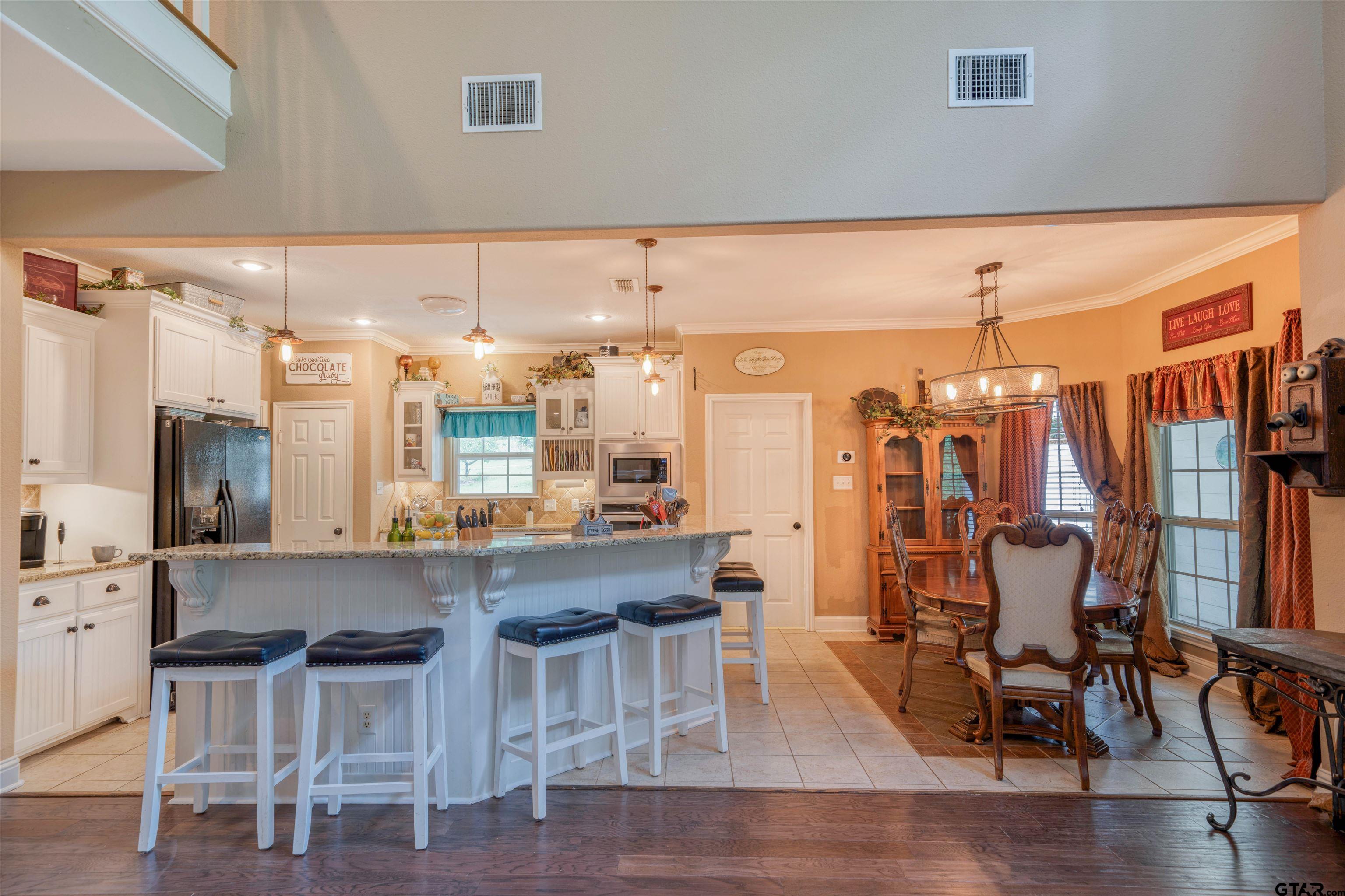 1776 Mustang Road Gilmer, TX 75645 - Photo 15 of 45 a dining hall with stainless steel appliances a dining table chairs and view living room