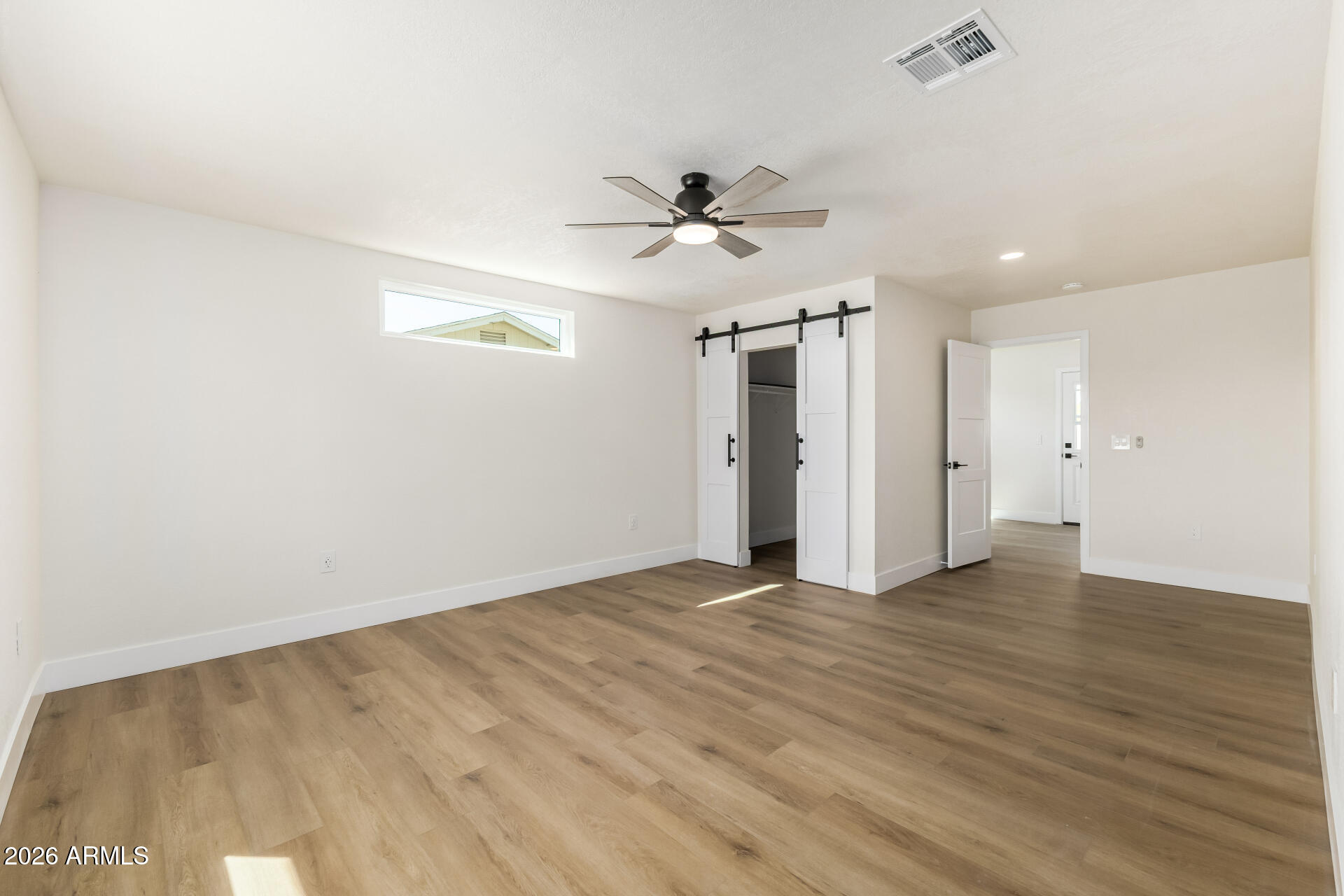 2890 South Mariposa Road Apache Junction, AZ 85119 - Photo 15 of 27 an empty room with wooden floor ceiling fan and window
