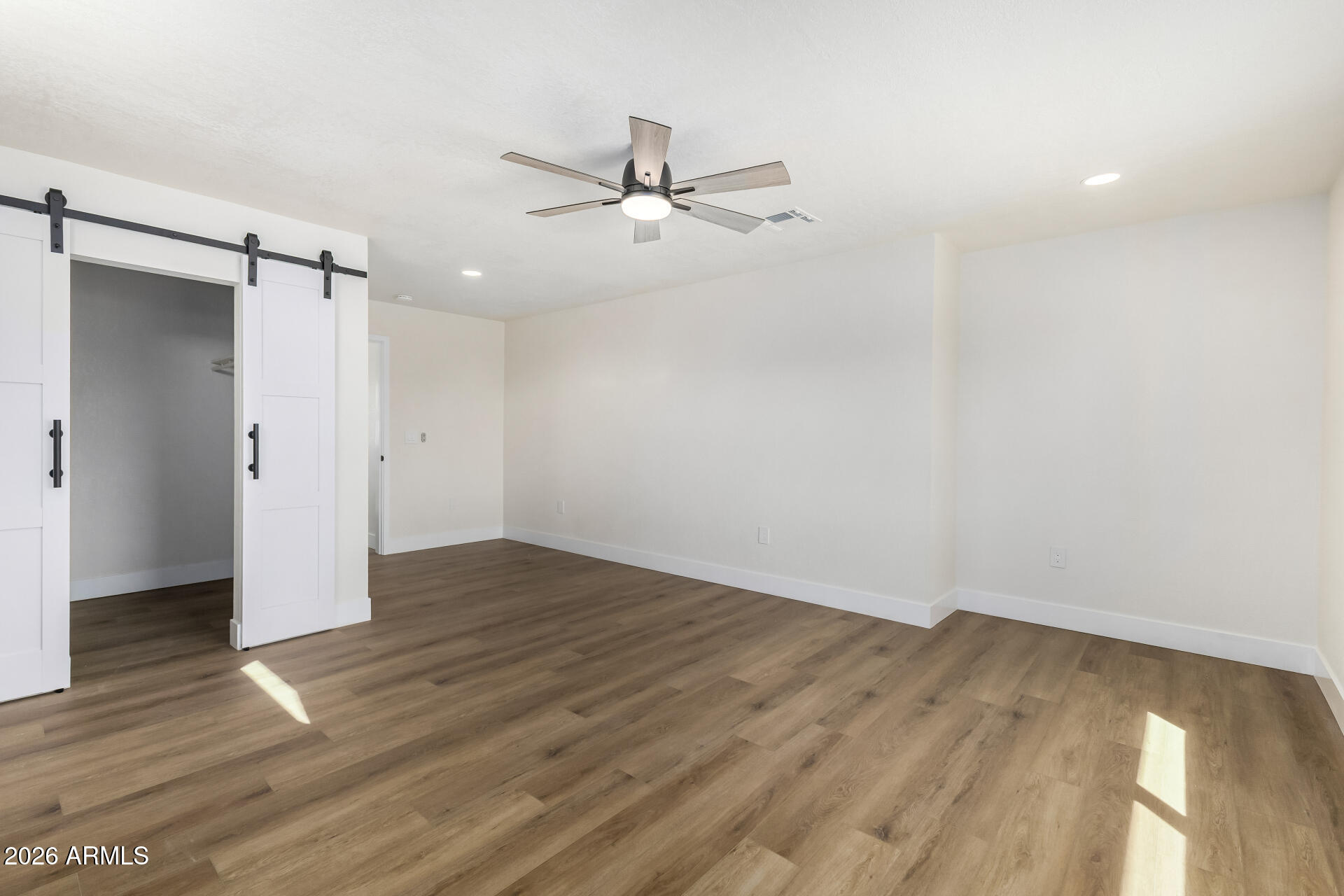 2890 South Mariposa Road Apache Junction, AZ 85119 - Photo 16 of 27 an empty room with wooden floor a ceiling fan and closet