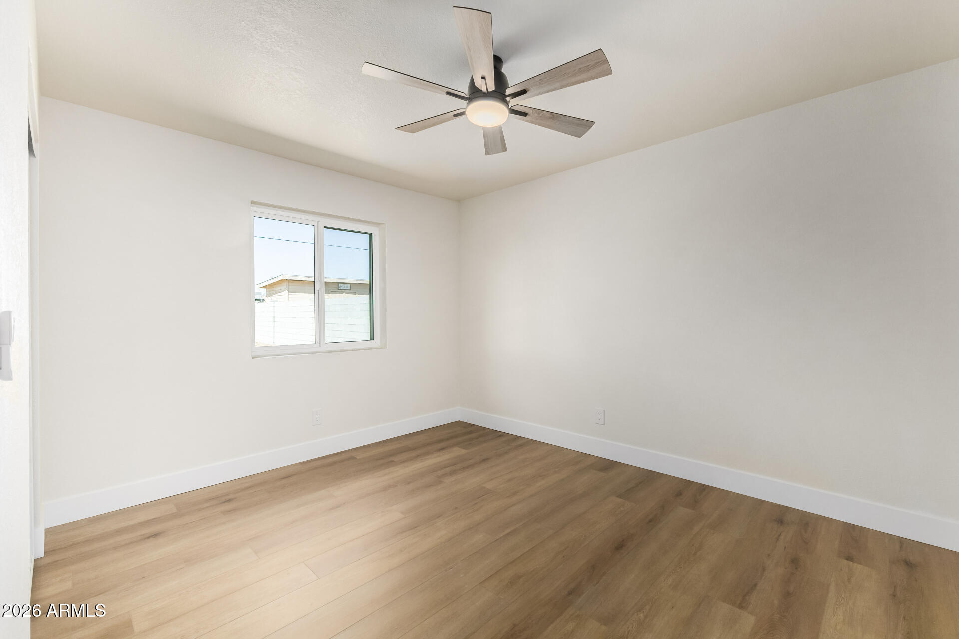 2890 South Mariposa Road Apache Junction, AZ 85119 - Photo 19 of 27 an empty room with a chandelier fan and windows