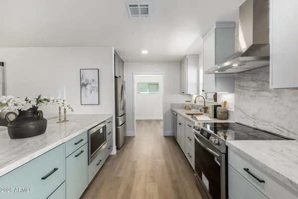 a kitchen with stainless steel appliances a sink stove and cabinets