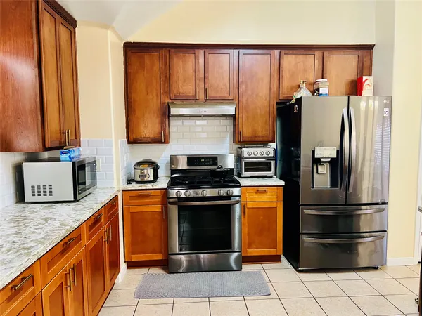 a kitchen with stainless steel appliances granite countertop a refrigerator and a stove