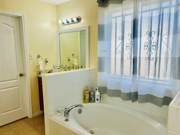 a bathroom with a tub sink and mirror