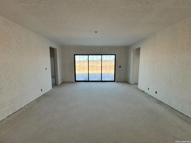 an empty room with windows and mirror