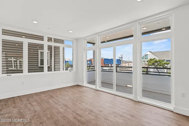 a view of empty room with kitchen and window