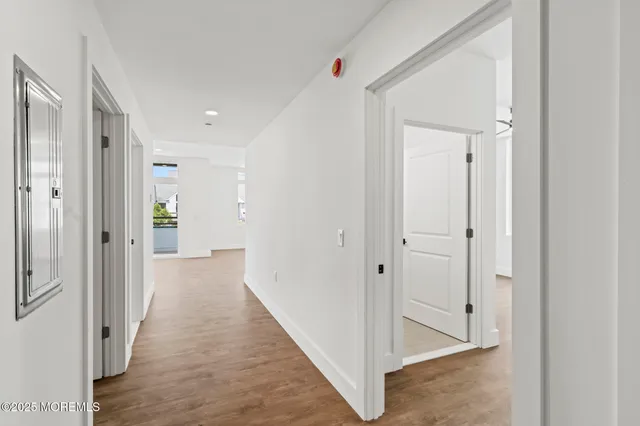 a view of a hallway with wooden floor and closet area
