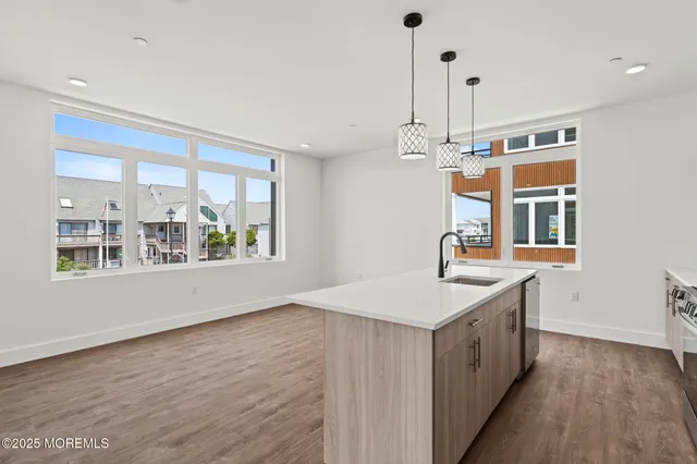 a kitchen with stainless steel appliances granite countertop a refrigerator a sink dishwasher a stove and a refrigerator