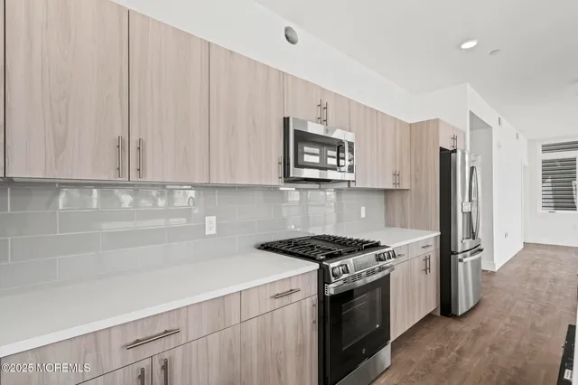 a kitchen with stainless steel appliances white cabinets and a stove top oven