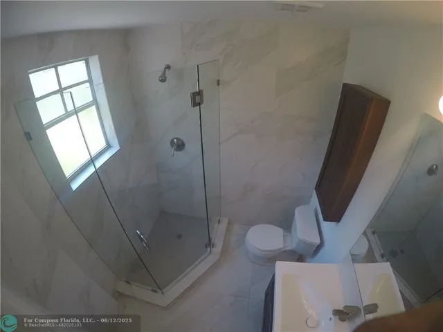 a bathroom with a shower a toilet and sink