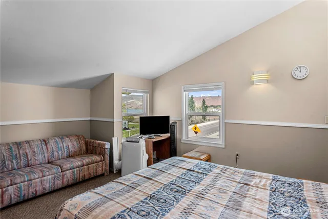 a bedroom with a bed and a lamp on the dresser