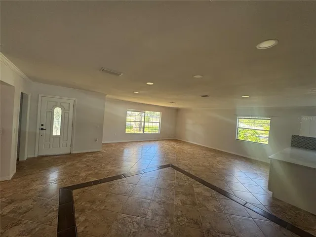 a view of empty room with window and wooden floor