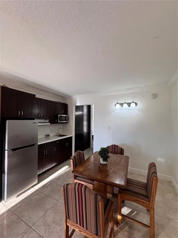 a kitchen with stainless steel appliances kitchen island granite countertop a table chairs in it and wooden floors