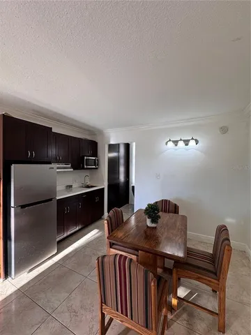 a kitchen with a table chairs and refrigerator
