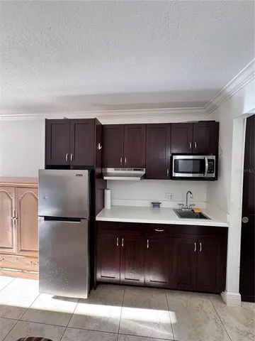 a kitchen with stainless steel appliances granite countertop a refrigerator and a stove top oven