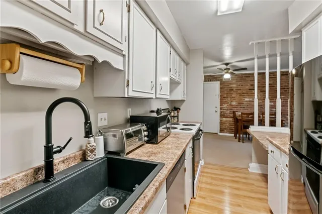 a kitchen with stainless steel appliances a stove a sink dishwasher and cabinets with wooden floor