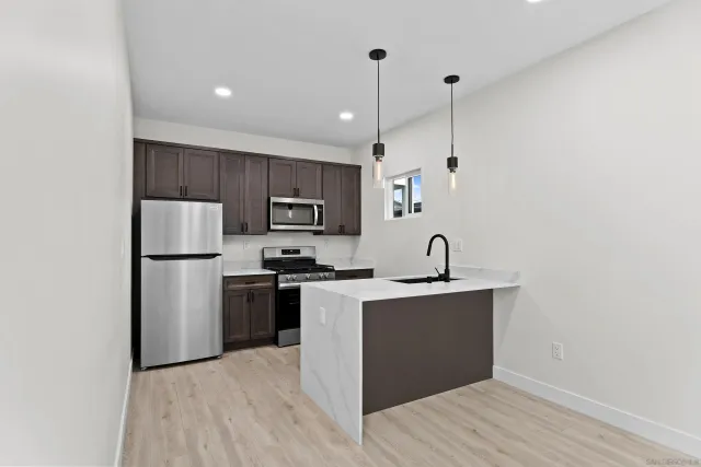 a kitchen with kitchen island a sink stainless steel appliances and cabinets