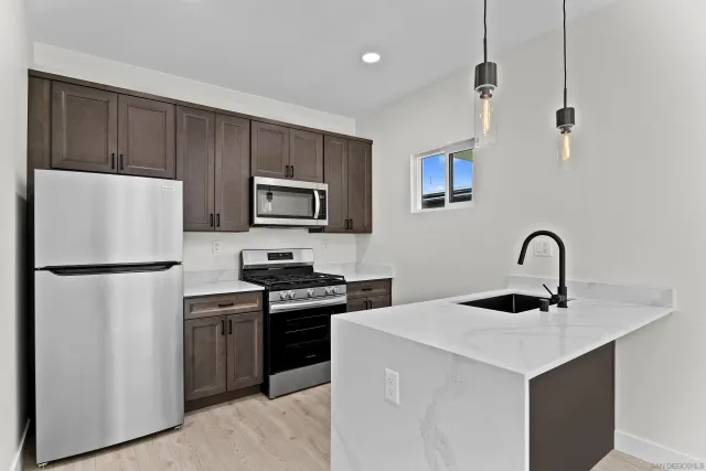 a kitchen with stainless steel appliances a refrigerator sink and white cabinets