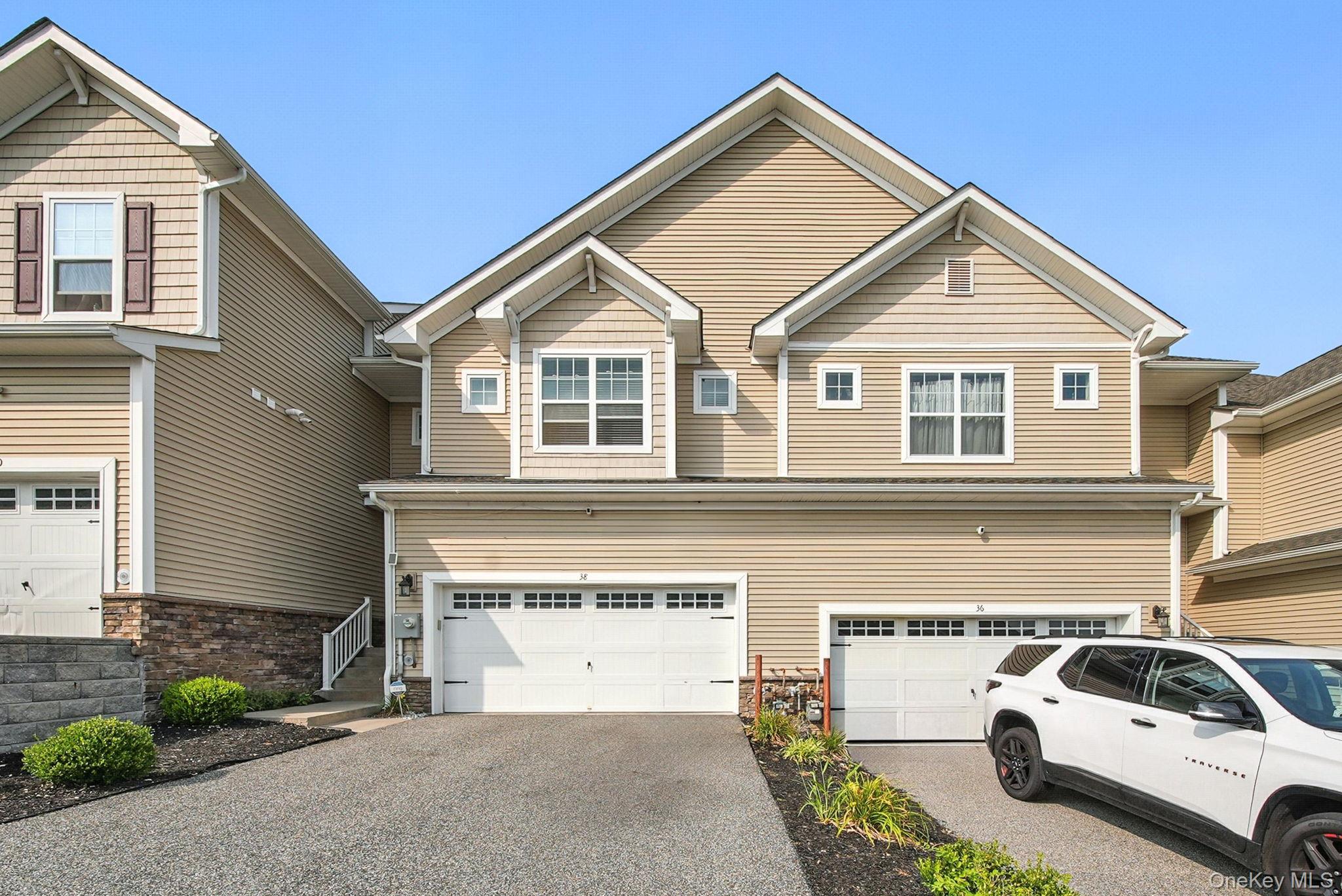 View of front of house featuring an attached 2 car garage and asphalt driveway