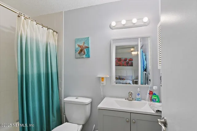 a bathroom with a sink vanity mirror and toilet