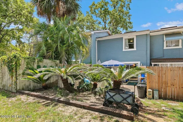 a view of backyard with outdoor seating and plants