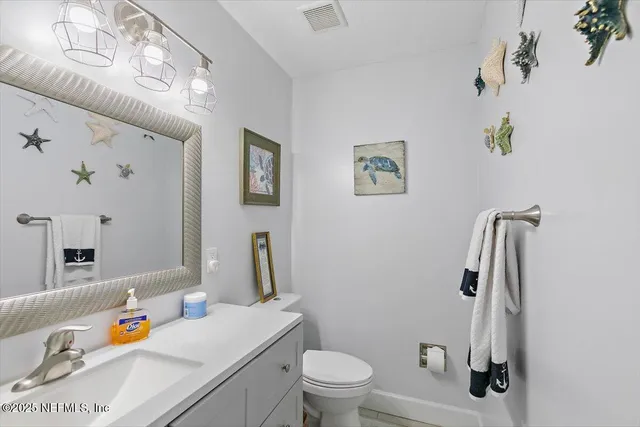 a bathroom with a sink vanity mirror and toilet
