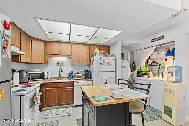 a kitchen with a sink a stove and a refrigerator