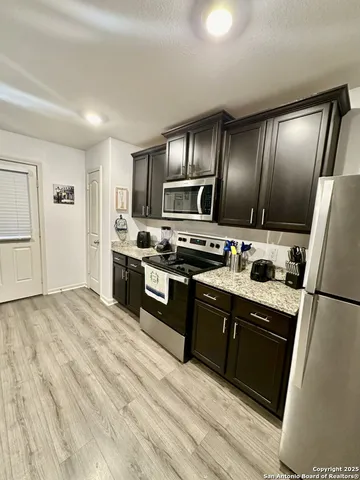 a kitchen with granite countertop stainless steel appliances and wooden cabinets