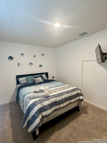 a bed sitting in a bedroom next to a window