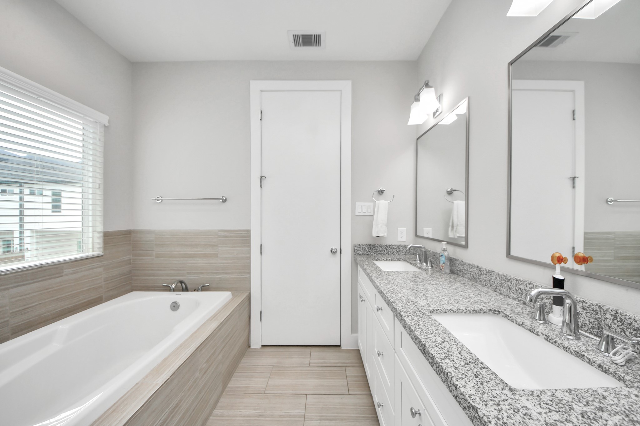 6715 Allegheny Street Houston, TX 77021 - Photo 10 of 18 a bathroom with a granite countertop tub a double vanity sink and a mirror