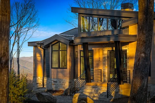a view of a hallway with wooden floor and a bathroom