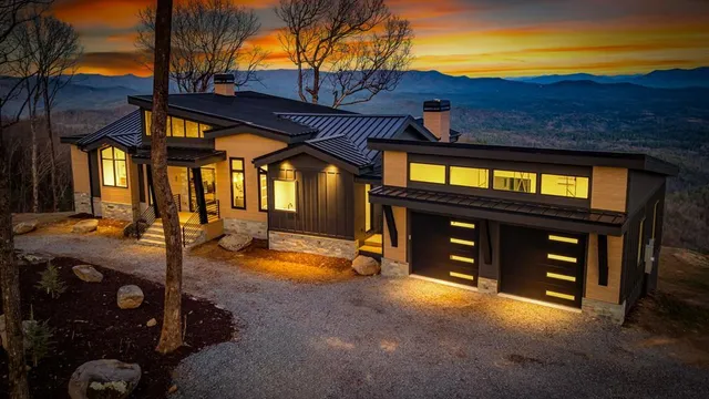a living room with furniture a fireplace and floor to ceiling windows