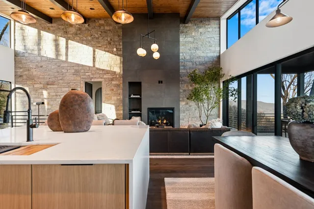 a dining room with furniture large windows and wooden floor