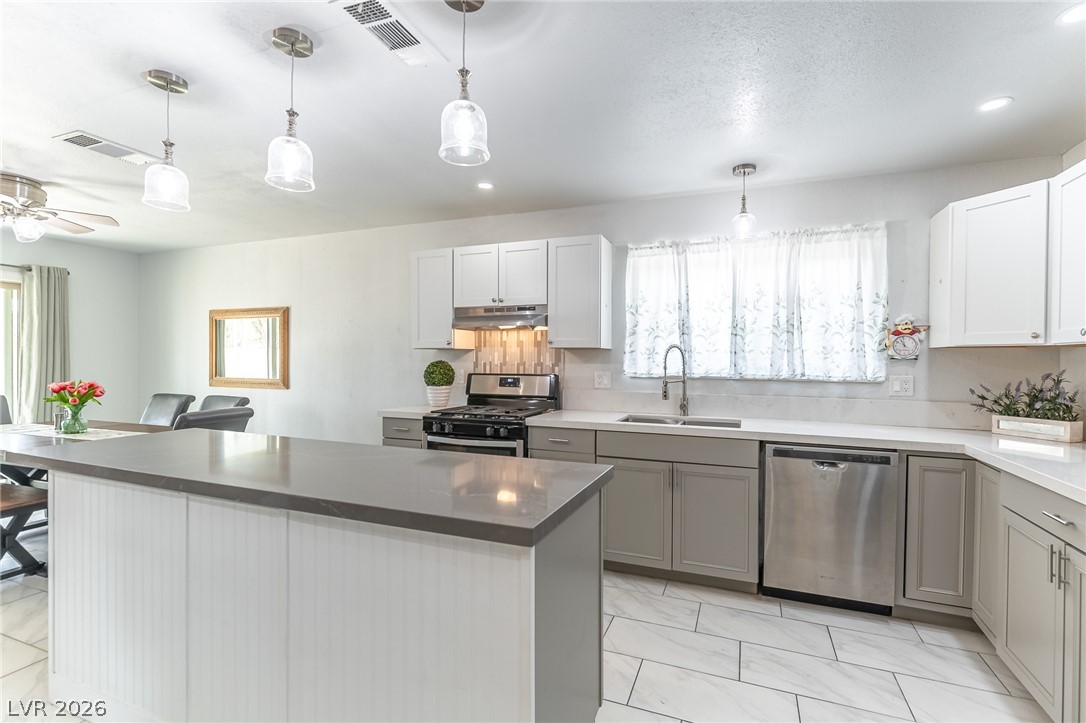 105 South Cimarron Road Las Vegas, NV 89145 - Photo 11 of 28 Smooth stone countertops and classic cabinetry elevate this stylish culinary workspace.