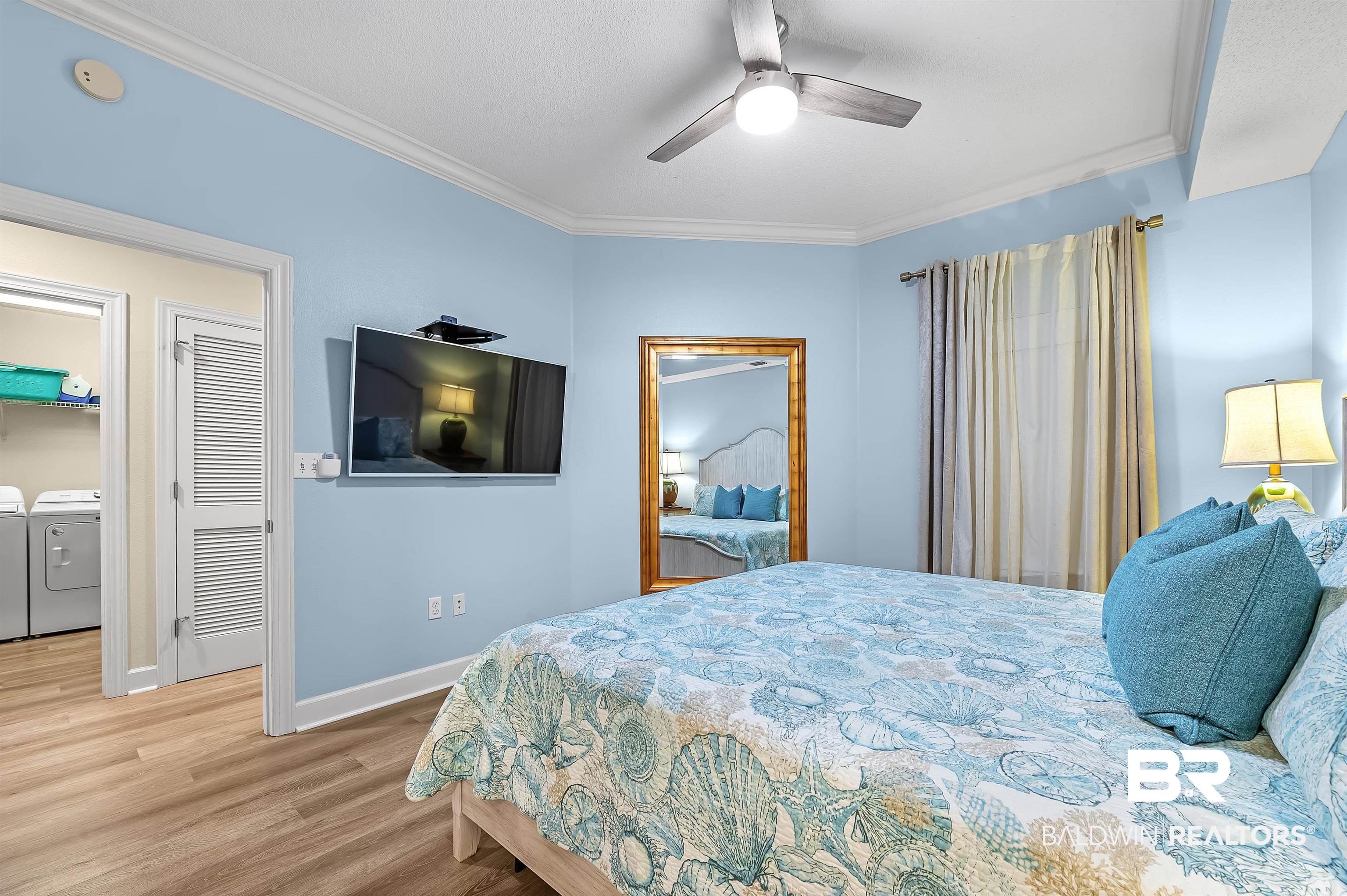 27582 Canal Road, Unit 2104 Orange Beach, AL 36561 - Photo 20 of 35 Bedroom with crown molding, separate washer and dryer, ceiling fan, king bed and hardwood / wood-style flooring