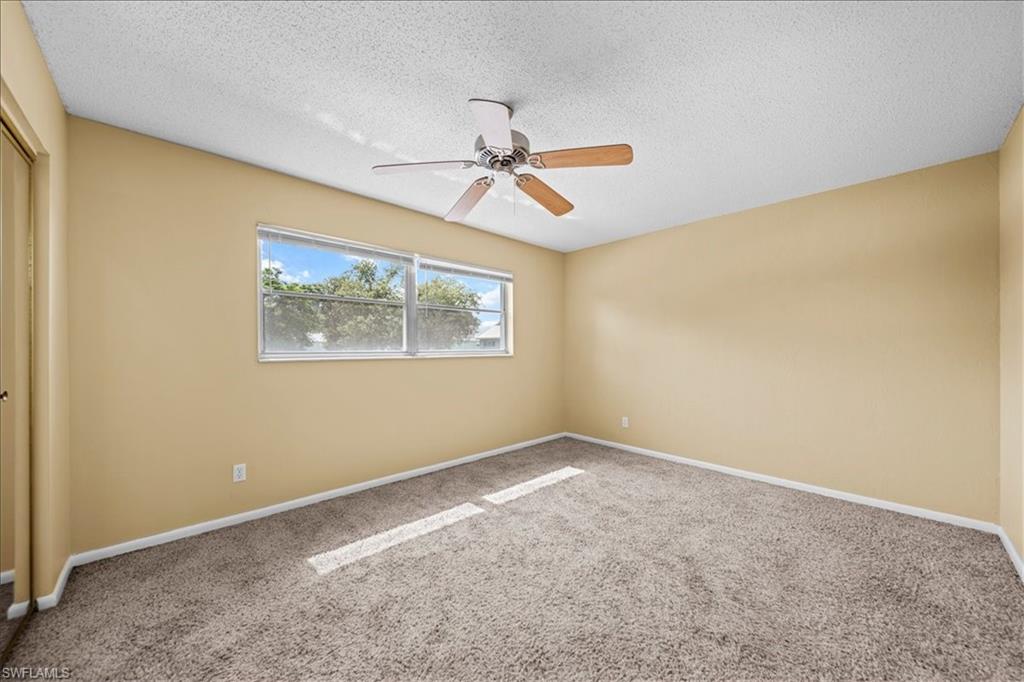 3225 East Riverside Drive, Unit 17A Fort Myers, FL 33916 - Photo 12 of 30 Empty room with carpet flooring, a textured ceiling, and ceiling fan