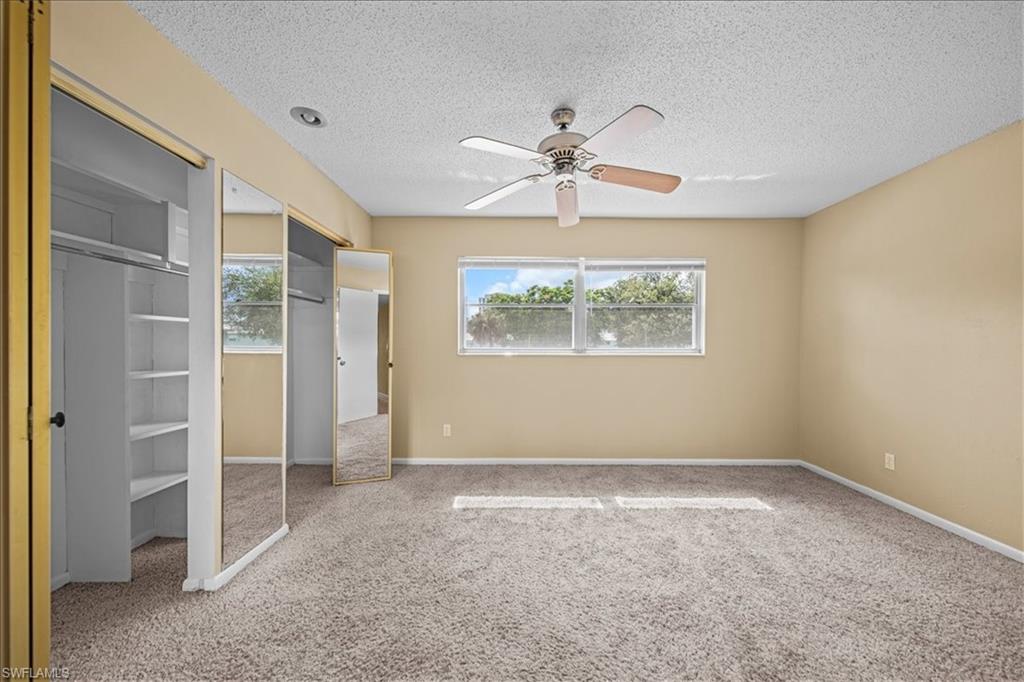 3225 East Riverside Drive, Unit 17A Fort Myers, FL 33916 - Photo 14 of 30 Unfurnished bedroom featuring carpet flooring, a ceiling fan, and a textured ceiling