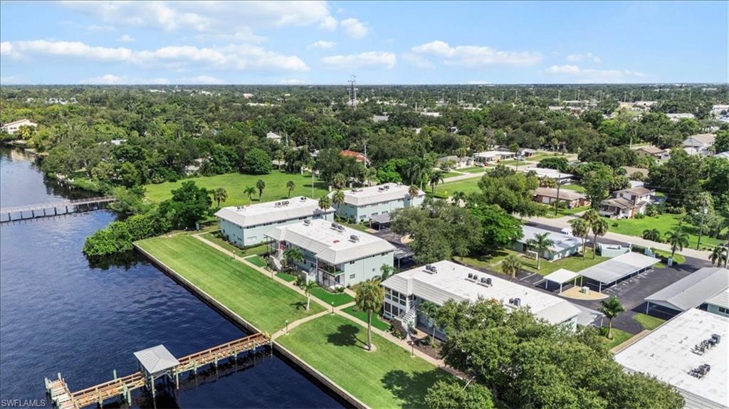 3225 East Riverside Drive, Unit 17A Fort Myers, FL 33916 - Photo 25 of 30 Drone / aerial view of a large body of water and a tree filled landscape