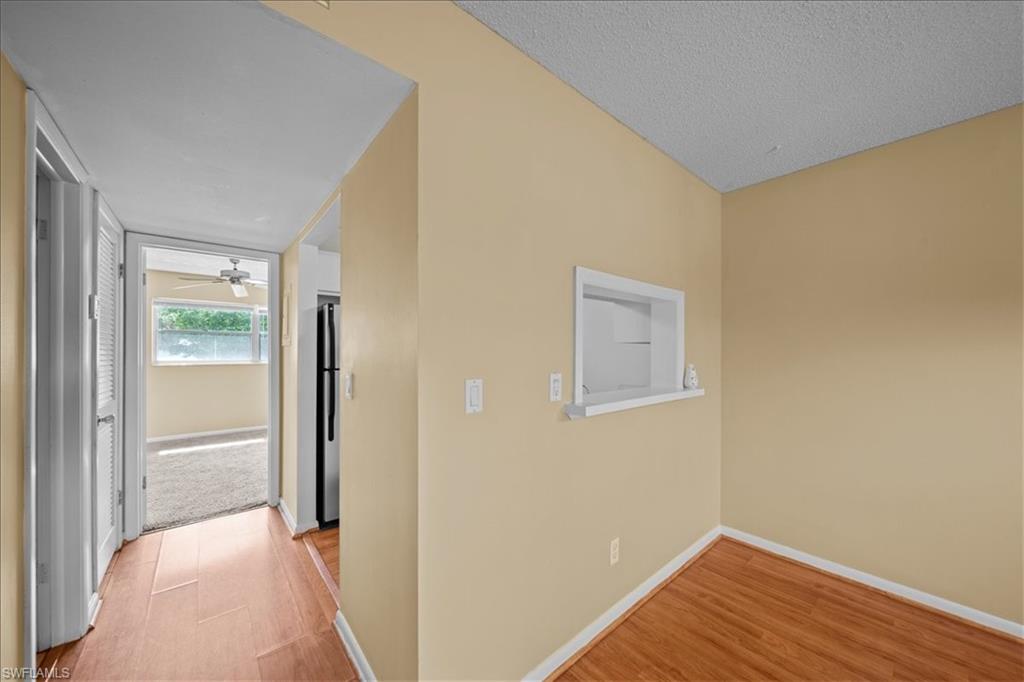 3225 East Riverside Drive, Unit 17A Fort Myers, FL 33916 - Photo 6 of 30 Hallway featuring light wood-style floors and a textured ceiling
