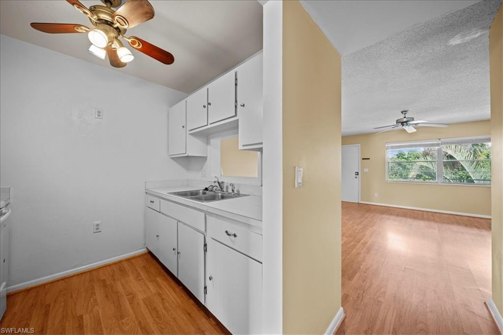 3225 East Riverside Drive, Unit 17A Fort Myers, FL 33916 - Photo 7 of 30 Kitchen featuring ceiling fan, white cabinets, light wood finished floors, and light countertops